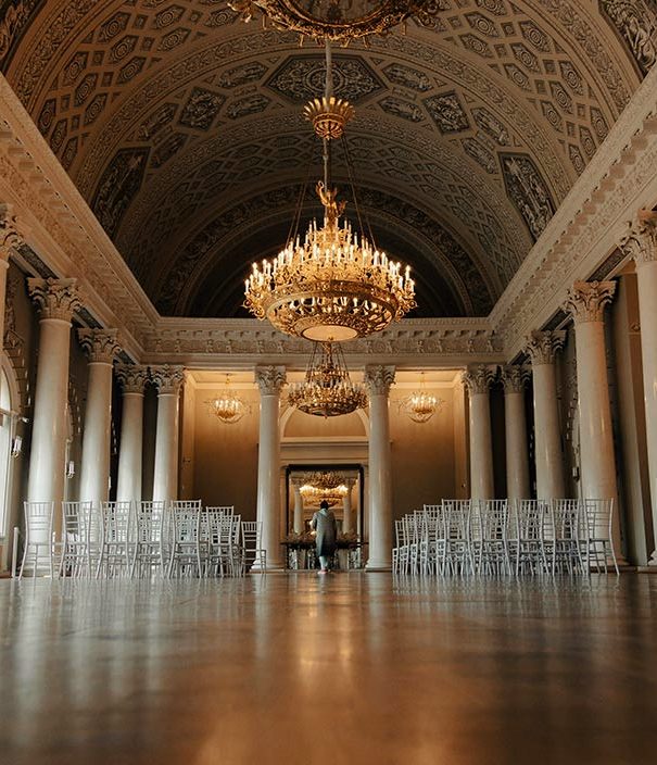 A ballroom with a coffered vaulted ceiling and a chandelier on a long chain
