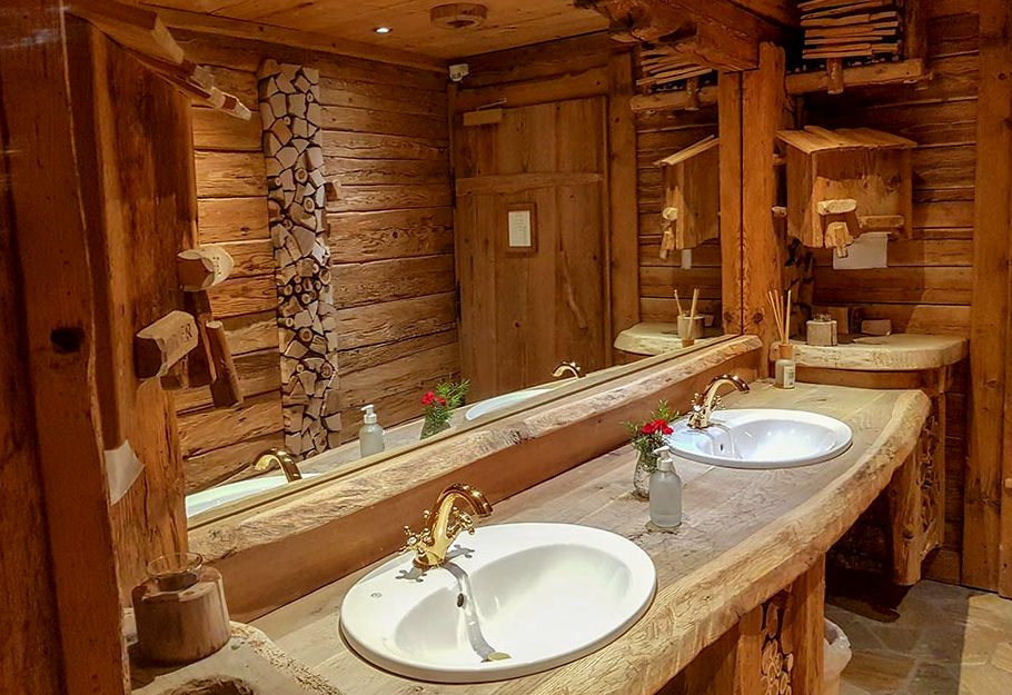 A bathroom lined in timber with two basins set into a heavy counter